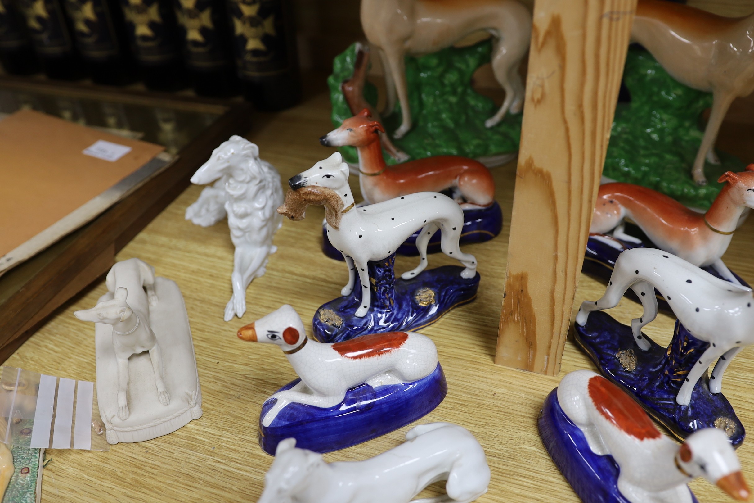 A collection of four pairs of Staffordshire dogs, together with nine other models of reclining hounds, tallest 25cm